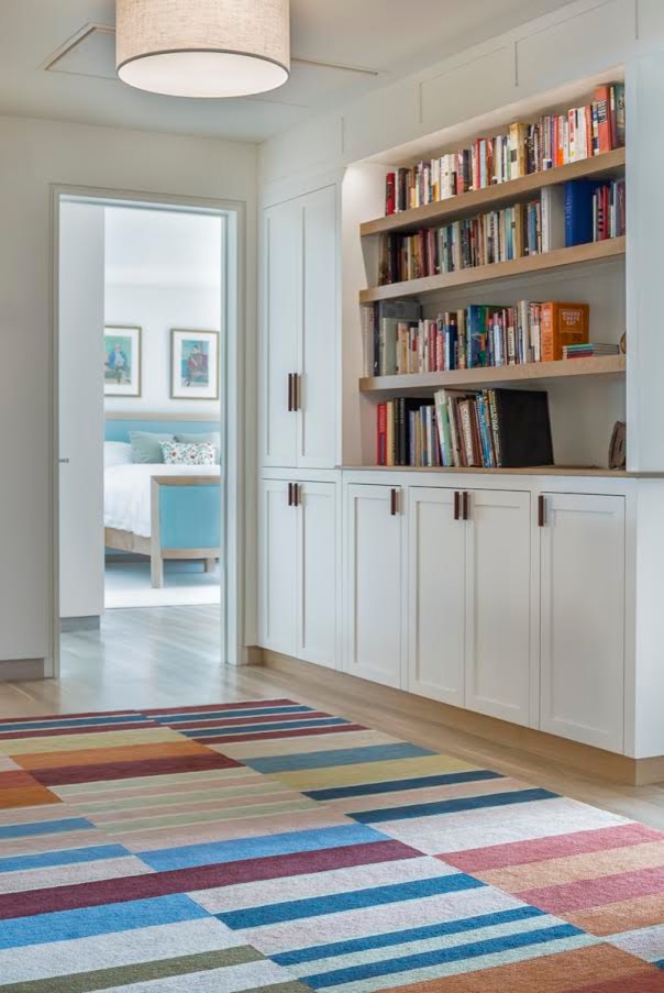 Inspiration for a mid-sized transitional hallway in Boston with white walls and light hardwood floors.