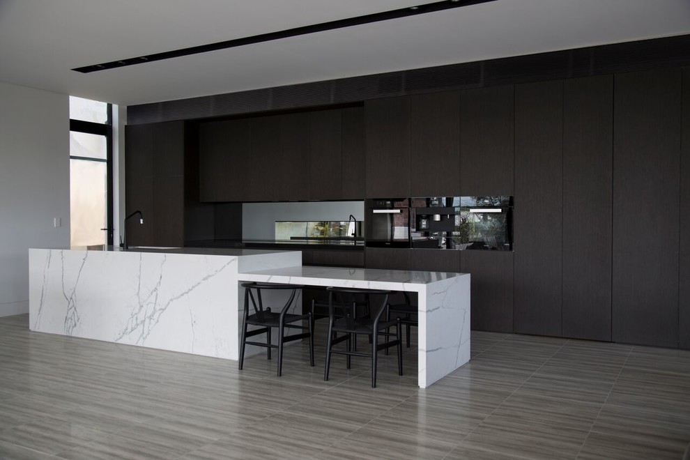 Photo of a contemporary single-wall eat-in kitchen in Sydney with an undermount sink, quartz benchtops, mirror splashback, ceramic floors, with island, flat-panel cabinets, brown cabinets and black appliances.