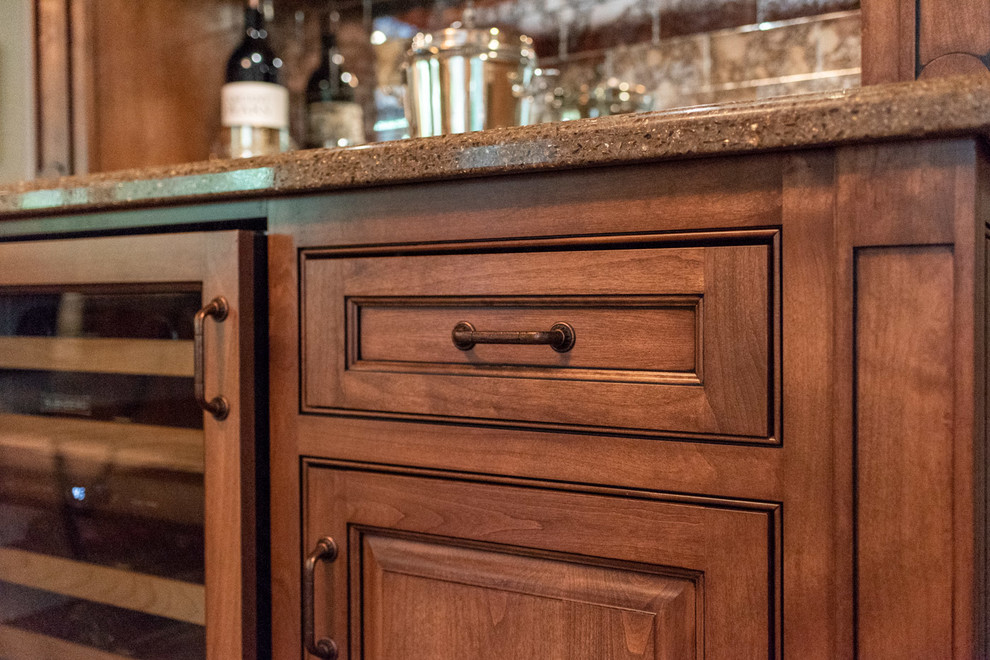 Mid-sized traditional single-wall home bar in San Luis Obispo with raised-panel cabinets, dark wood cabinets, quartz benchtops, mirror splashback, dark hardwood floors, brown floor and multi-coloured benchtop.