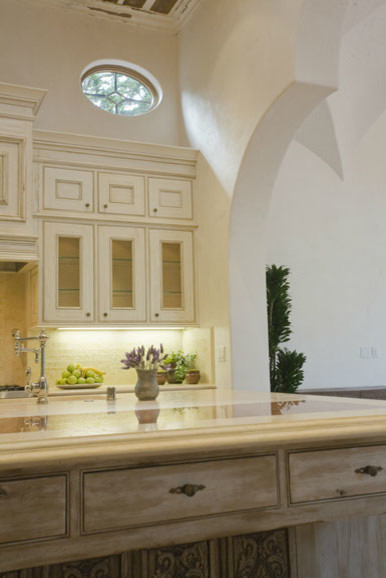 Kitchen pantry - mid-sized galley terra-cotta tile kitchen pantry idea with beige cabinets, limestone countertops, beige backsplash, custom tile backsplash, paneled appliances, white walls and an island