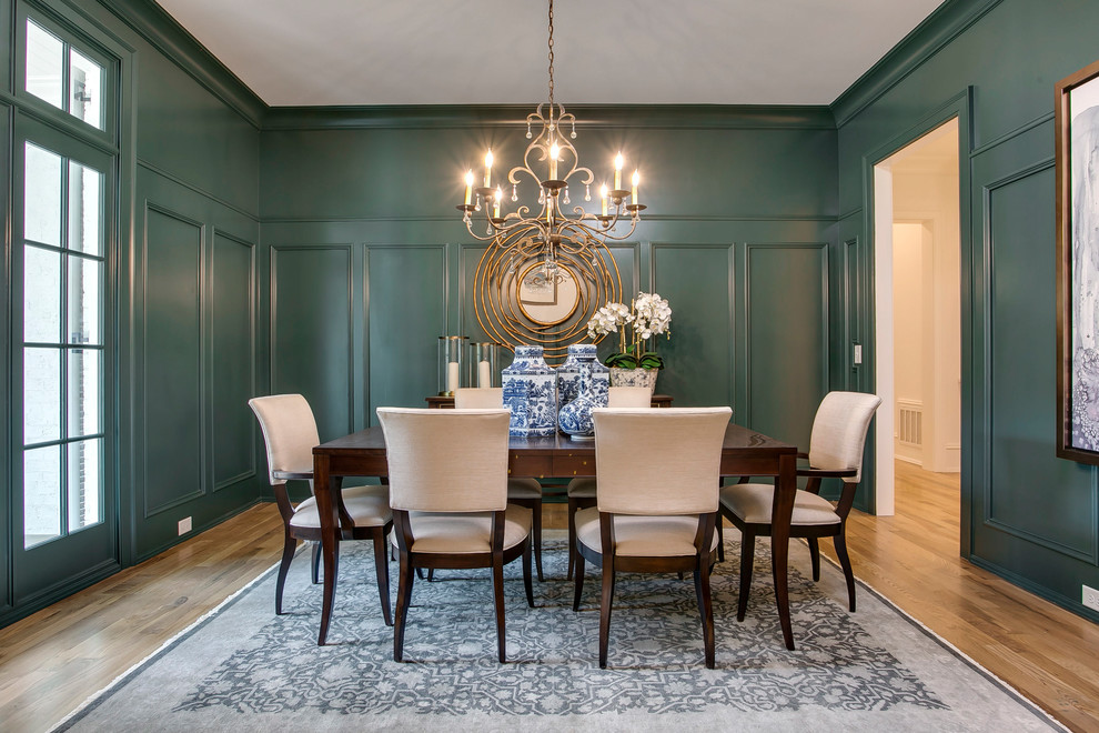 This is an example of a traditional separate dining room in Raleigh with medium hardwood floors, brown floor and green walls.