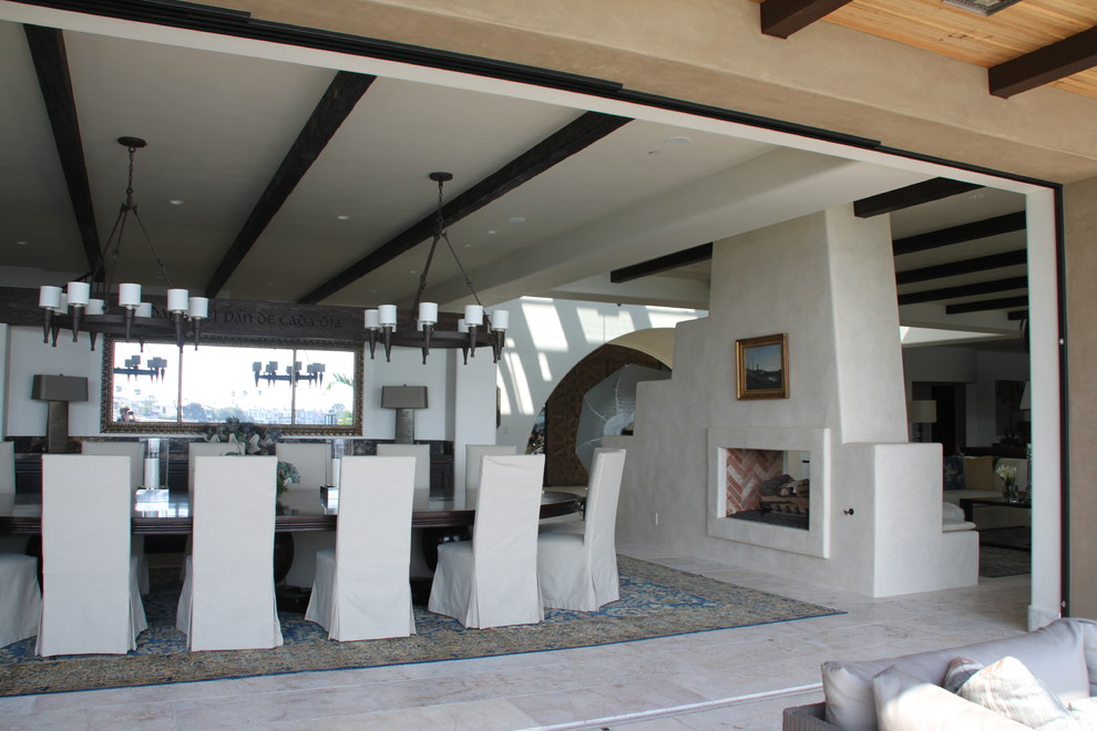 Large tuscan enclosed dining room photo in Orange County with white walls and a two-sided fireplace