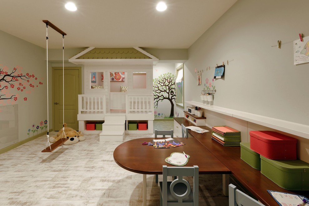 Creative and Unique Playroom - A perfect playroom space for two young girls to grow into.  The space contains a custom made playhouse, complete with hidden trap door, custom built in benches with plenty of toy storage and bench cushions for reading, lounging or play pretend.  In order to mimic an outdoor space, we added an indoor swing.  The side of the playhouse has a small soft area with green carpeting to mimic grass, and a small picket fence.  The tree wall stickers add to the theme.  A huge highlight to the space is the custom designed, custom built craft table with plenty of storage for all kinds of craft supplies.  The rustic laminate wood flooring adds to the cottage theme.
Bob Narod Photography