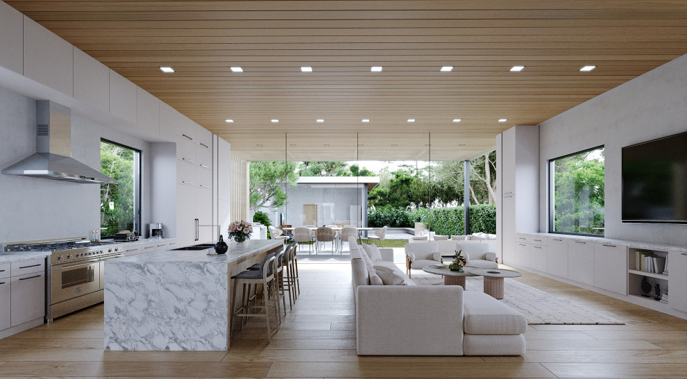 Expansive contemporary galley open plan kitchen in Los Angeles with an integrated sink, flat-panel cabinets, white cabinets, marble worktops, white splashback, coloured appliances, light hardwood flooring, an island, brown floors, multicoloured worktops and a wood ceiling.