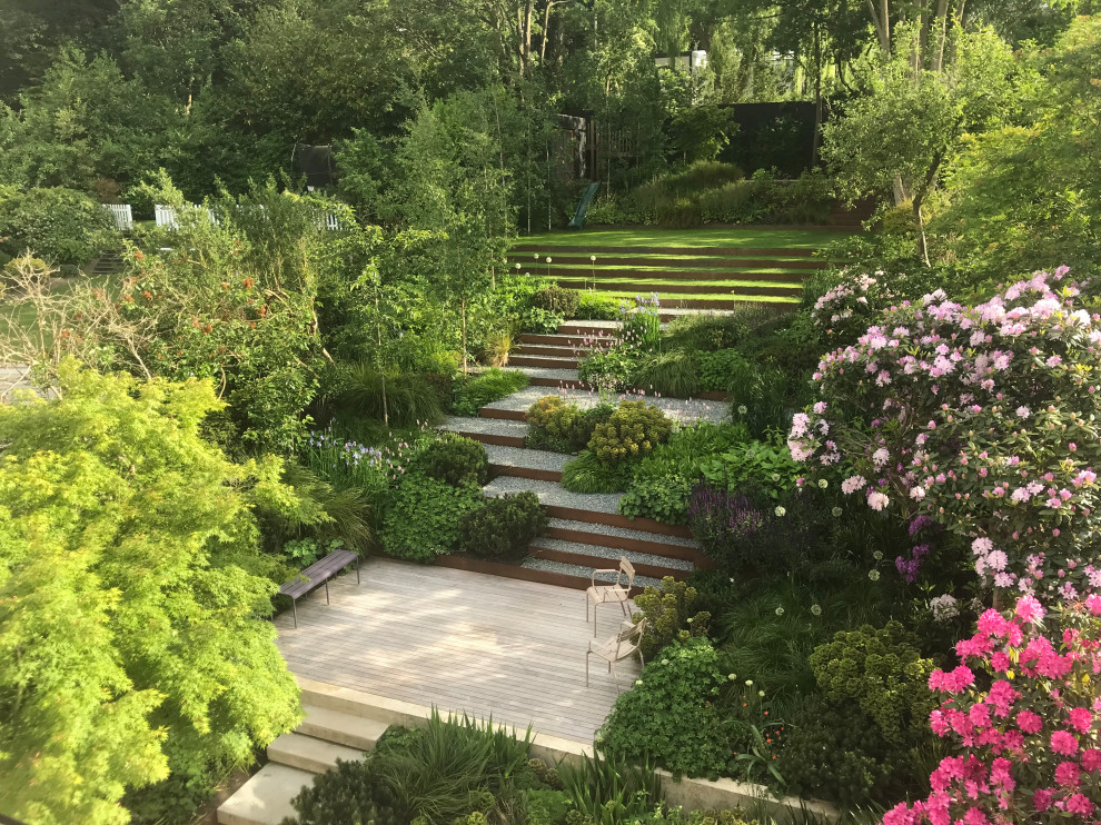 Photo of a large contemporary backyard formal garden in London with a garden path.