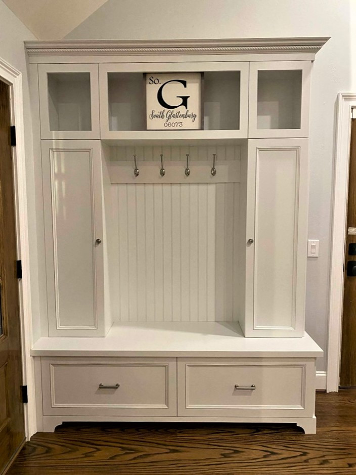 This is an example of a large country storage and wardrobe in Other with white cabinets.