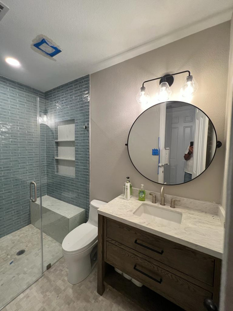 Example of a mid-sized island style kids' green tile and ceramic tile marble floor, white floor and single-sink bathroom design in Houston with shaker cabinets, brown cabinets, a two-piece toilet, beige walls, an undermount sink, quartz countertops, a hinged shower door, white countertops, a niche and a freestanding vanity