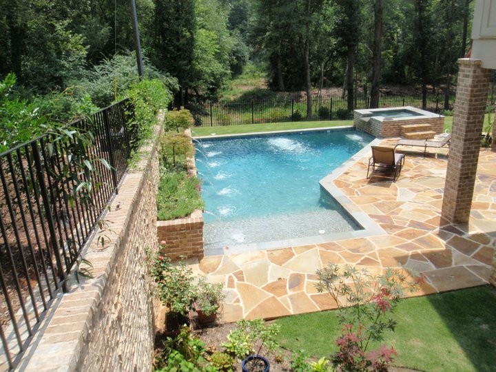 Design ideas for a large transitional courtyard custom-shaped natural pool in Atlanta with a hot tub and natural stone pavers.