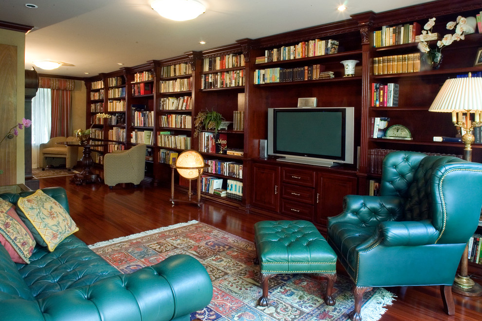 Inredning av ett klassiskt mycket stort arbetsrum, med ett bibliotek, beige väggar, mörkt trägolv, ett inbyggt skrivbord och brunt golv