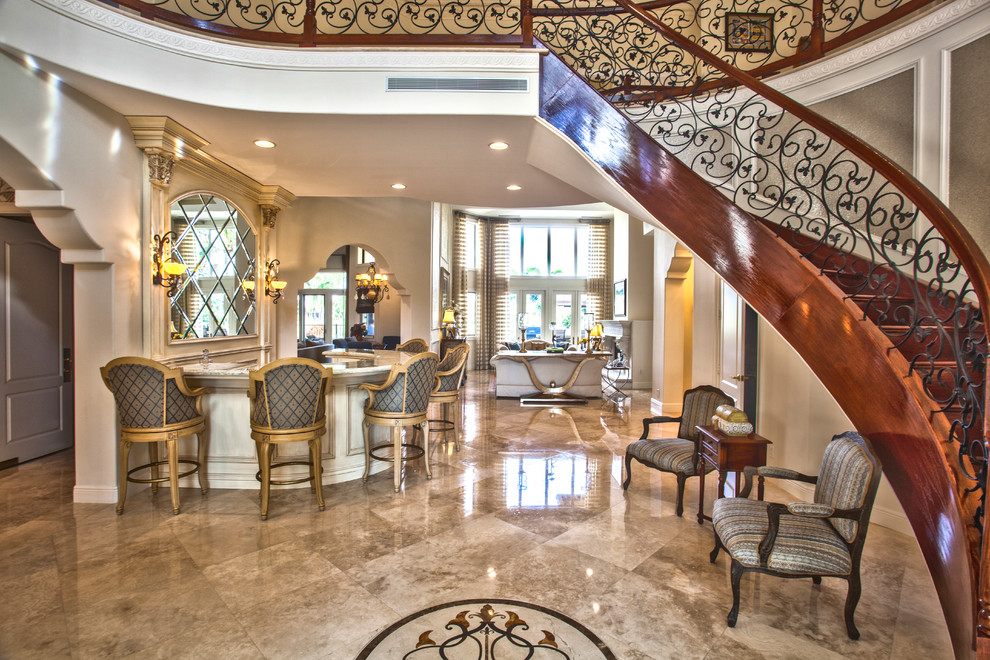 Expansive traditional foyer in Miami with beige walls, marble floors and a double front door.