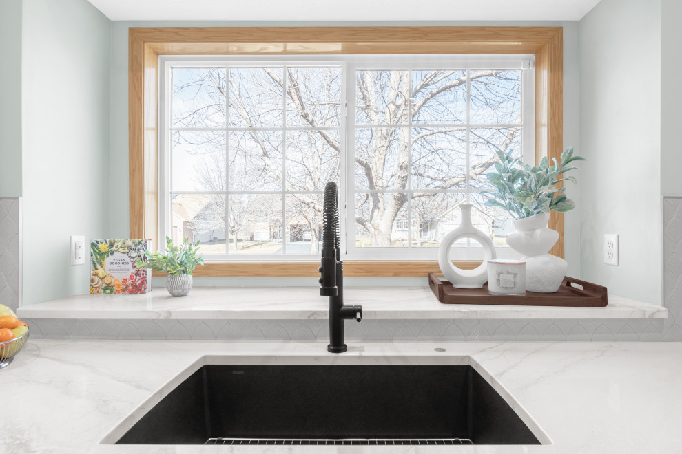 Inspiration for a mid-sized transitional l-shaped light wood floor and beige floor kitchen remodel in Minneapolis with an undermount sink, shaker cabinets, white cabinets, quartz countertops, white backsplash, ceramic backsplash, stainless steel appliances, an island and white countertops