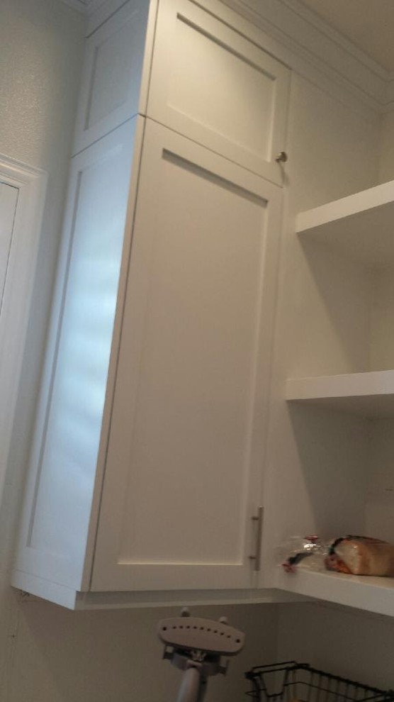 Inspiration for a large transitional u-shaped dark wood floor kitchen pantry remodel in Orange County with recessed-panel cabinets, white cabinets and solid surface countertops