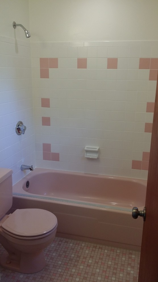 Small retro bathroom in DC Metro with white cabinets, an alcove bath, an alcove shower, a two-piece toilet, pink tiles and mosaic tile flooring.