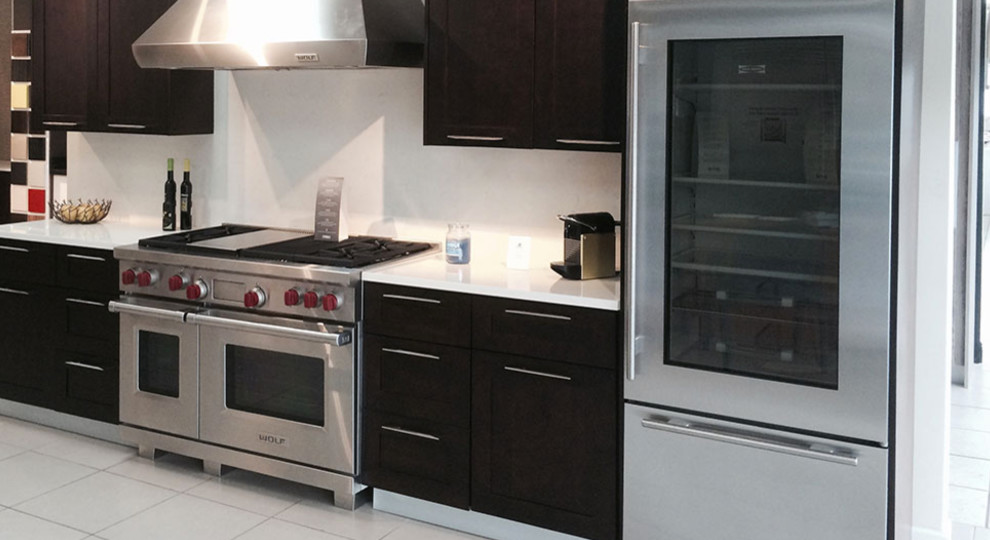 Foto de cocina actual de tamaño medio con armarios estilo shaker, puertas de armario de madera en tonos medios, encimera de cuarzo compacto y electrodomésticos de acero inoxidable