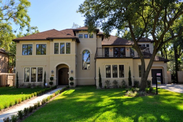 This is an example of a large mediterranean two-storey adobe exterior in Houston.