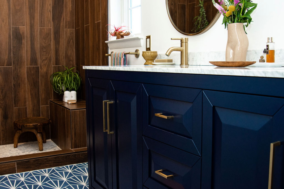 Eklektisk inredning av ett vit vitt en-suite badrum, med luckor med infälld panel, blå skåp, en öppen dusch, vita väggar, klinkergolv i porslin, ett undermonterad handfat, marmorbänkskiva och blått golv