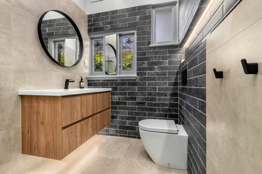 This is an example of a mid-sized contemporary bathroom in Melbourne with furniture-like cabinets, an open shower, a one-piece toilet, porcelain floors, an undermount sink, engineered quartz benchtops, an open shower, a niche, a single vanity, a floating vanity, medium wood cabinets, gray tile, porcelain tile and white benchtops.