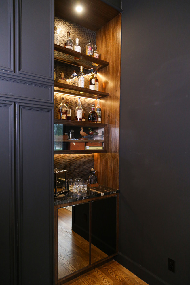 Inspiration for a mid-sized transitional home bar in Other with dark wood cabinets, quartz benchtops, light hardwood floors and black benchtop.