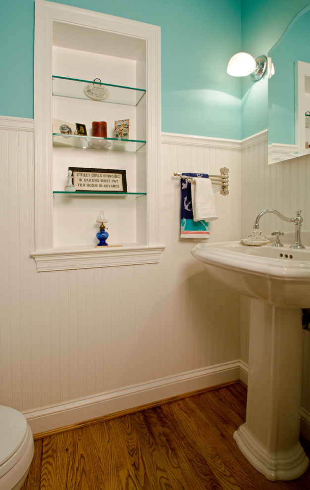 Design ideas for a small eclectic powder room in DC Metro with a pedestal sink, a two-piece toilet, blue walls and medium hardwood floors.