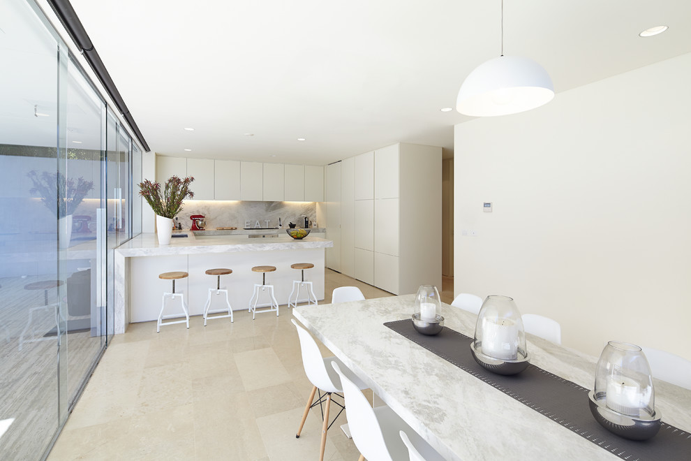 Inspiration for a contemporary kitchen in Melbourne with white cabinets, marble benchtops, limestone floors and with island.