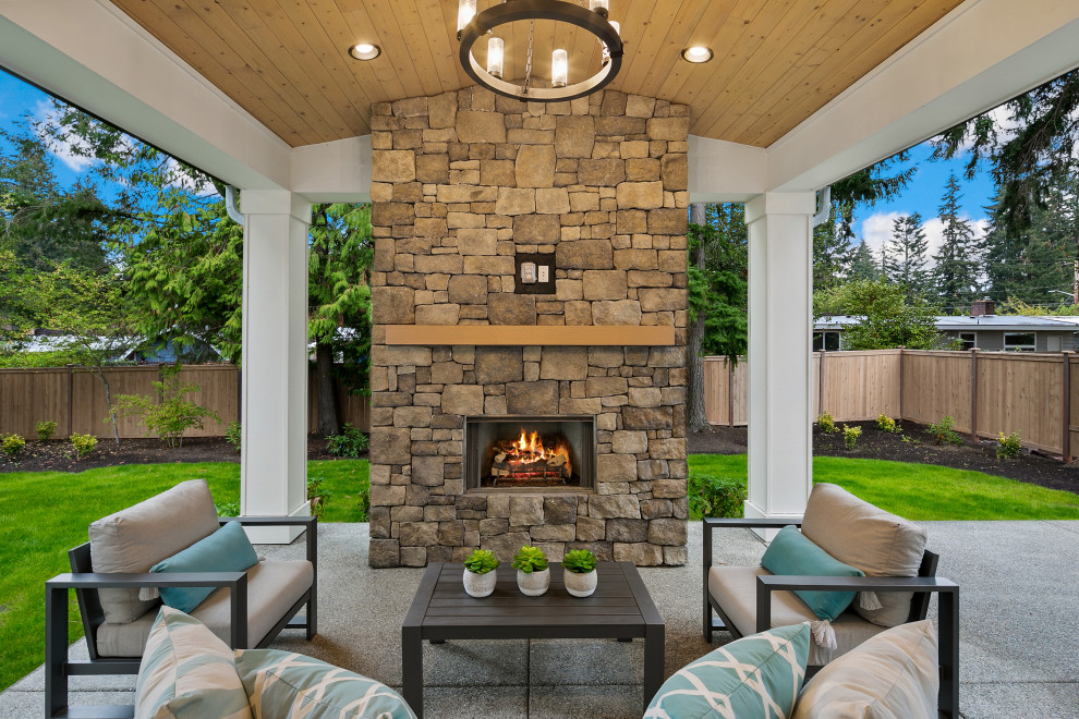 Design ideas for a large country back patio in Seattle with a fireplace, concrete slabs and a roof extension.