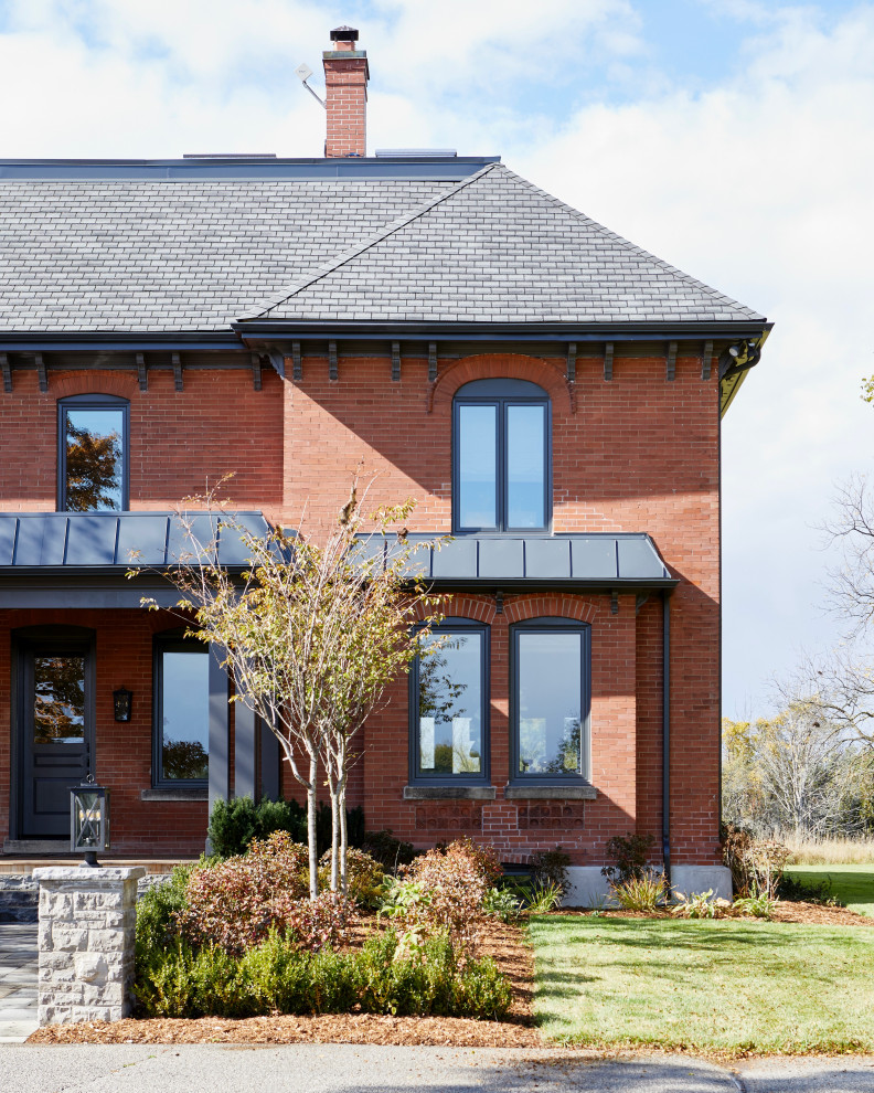Huge traditional red three-story brick exterior home idea in Toronto with a shingle roof and a black roof