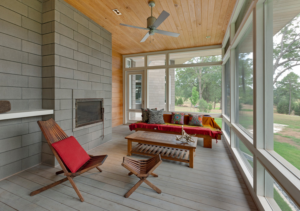 Mid-sized modern sunroom in Dallas with light hardwood floors, a standard fireplace, a standard ceiling, a concrete fireplace surround and grey floor.