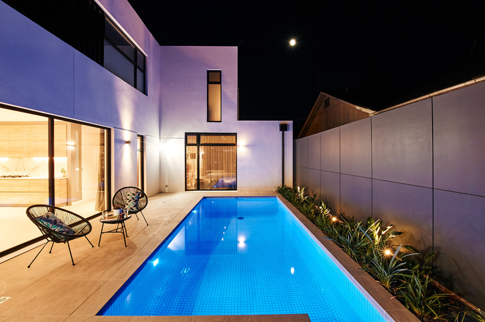 Photo of a mid-sized contemporary courtyard rectangular lap pool in Melbourne with concrete pavers.