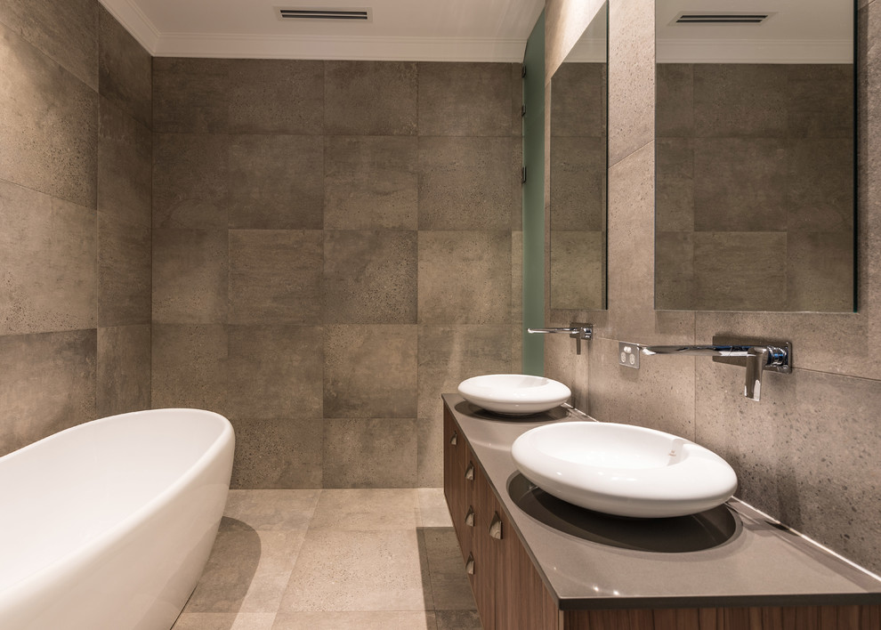 Inspiration for a contemporary master bathroom in Sydney with flat-panel cabinets, medium wood cabinets, a freestanding tub, gray tile, cement tile, grey walls, concrete floors, a vessel sink, grey floor and grey benchtops.