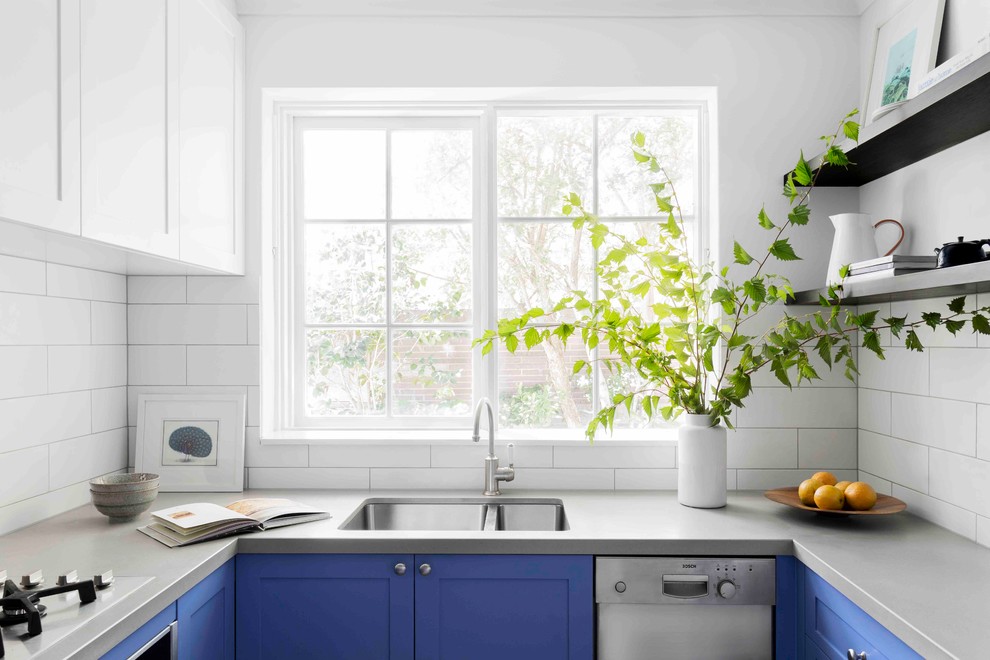 Inspiration for a small eclectic u-shaped separate kitchen in Melbourne with an undermount sink, shaker cabinets, blue cabinets, quartz benchtops, white splashback, porcelain splashback, stainless steel appliances, cement tiles, no island and grey floor.