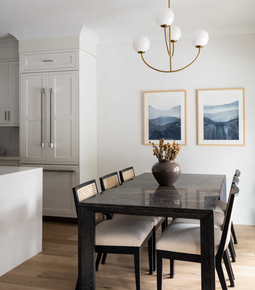 Cette photo montre une petite salle à manger ouverte sur la cuisine chic avec un mur gris et parquet clair.