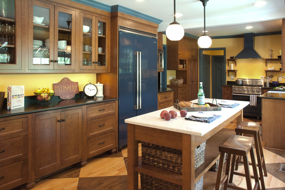 This is an example of a country u-shaped separate kitchen in Cleveland with a farmhouse sink, glass-front cabinets, dark wood cabinets, coloured appliances, medium hardwood floors and with island.