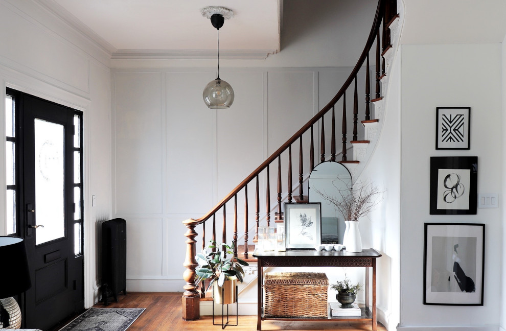 Example of a transitional wooden curved wood railing and wall paneling staircase design in Toronto