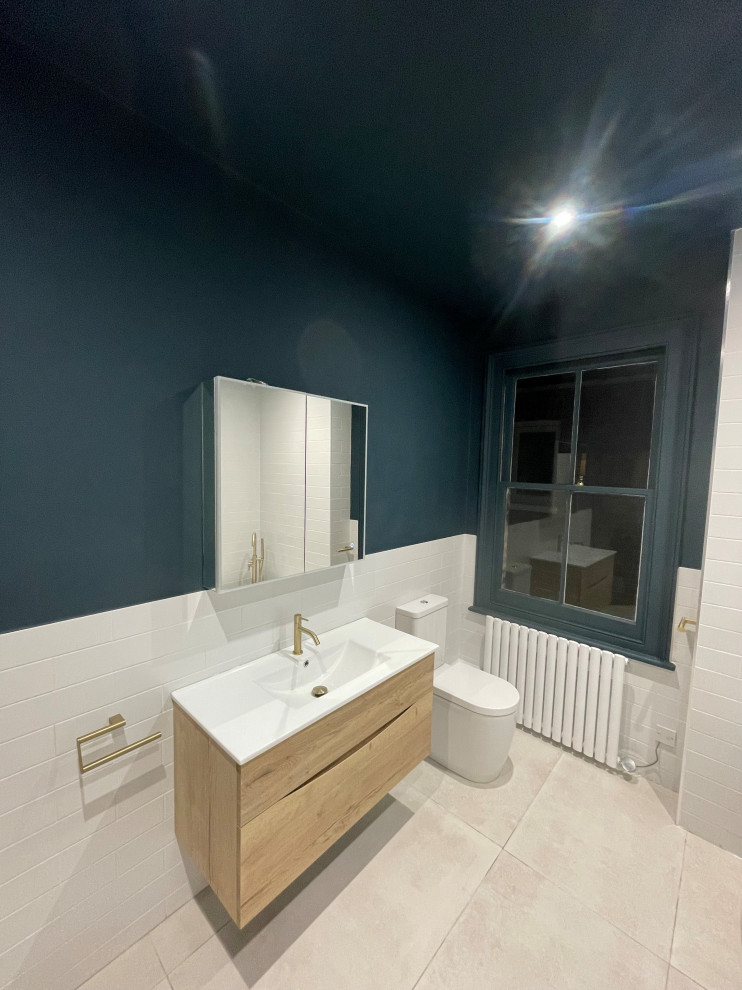 Photo of a large modern family bathroom in London with flat-panel cabinets, light wood cabinets, a freestanding bath, a walk-in shower, blue walls, porcelain flooring, grey floors, an open shower, a single sink and a floating vanity unit.