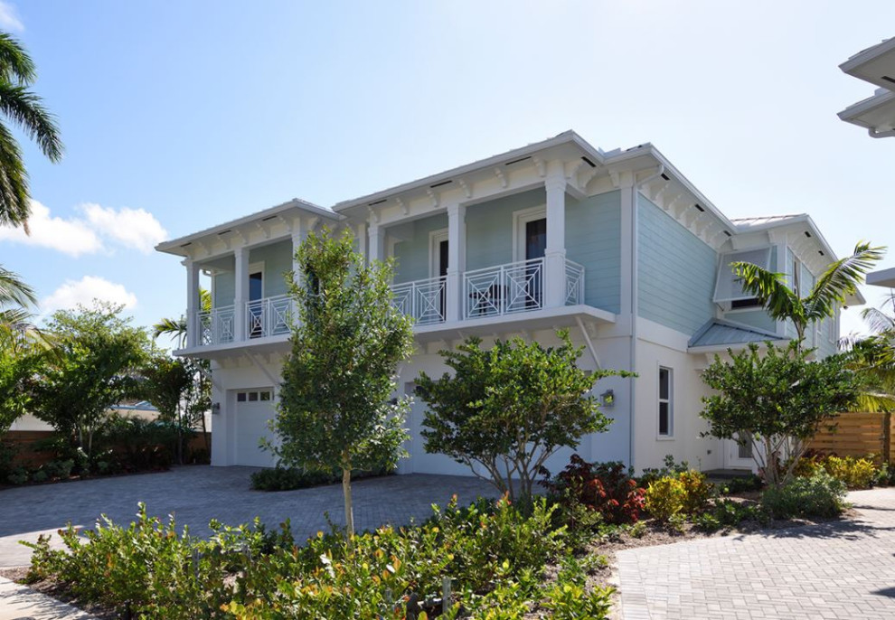 Immagine della facciata di una casa a schiera grande blu tropicale a due piani con rivestimenti misti, tetto a padiglione, copertura in metallo o lamiera e tetto grigio