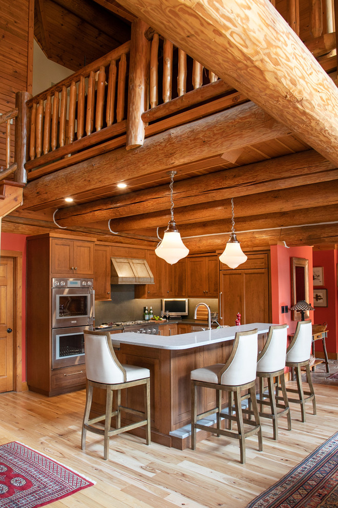 Mid-sized mountain style l-shaped light wood floor open concept kitchen photo in Milwaukee with recessed-panel cabinets, medium tone wood cabinets, quartz countertops, gray backsplash, stone slab backsplash, stainless steel appliances, an island and gray countertops