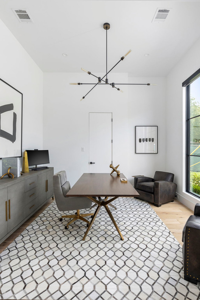 Foto de despacho minimalista de tamaño medio con paredes blancas, suelo de madera clara, escritorio independiente y suelo beige