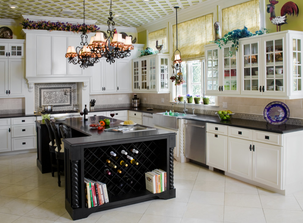Inspiration for a large traditional u-shaped eat-in kitchen in Chicago with a farmhouse sink, beaded inset cabinets, white cabinets, granite benchtops, beige splashback, mosaic tile splashback, stainless steel appliances, limestone floors and with island.