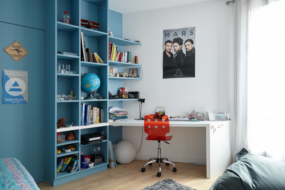 Design ideas for a mid-sized contemporary gender-neutral kids' room in Paris with light hardwood floors and multi-coloured walls.