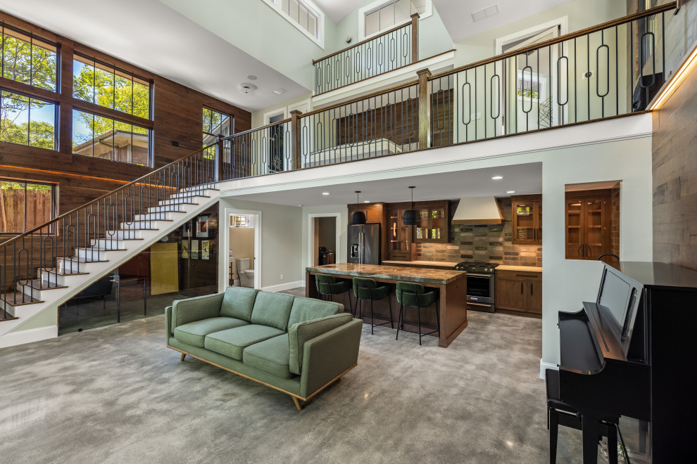 Esempio di un ampio soggiorno moderno aperto con pareti marroni, pavimento in cemento, pavimento grigio, soffitto a volta e pannellatura