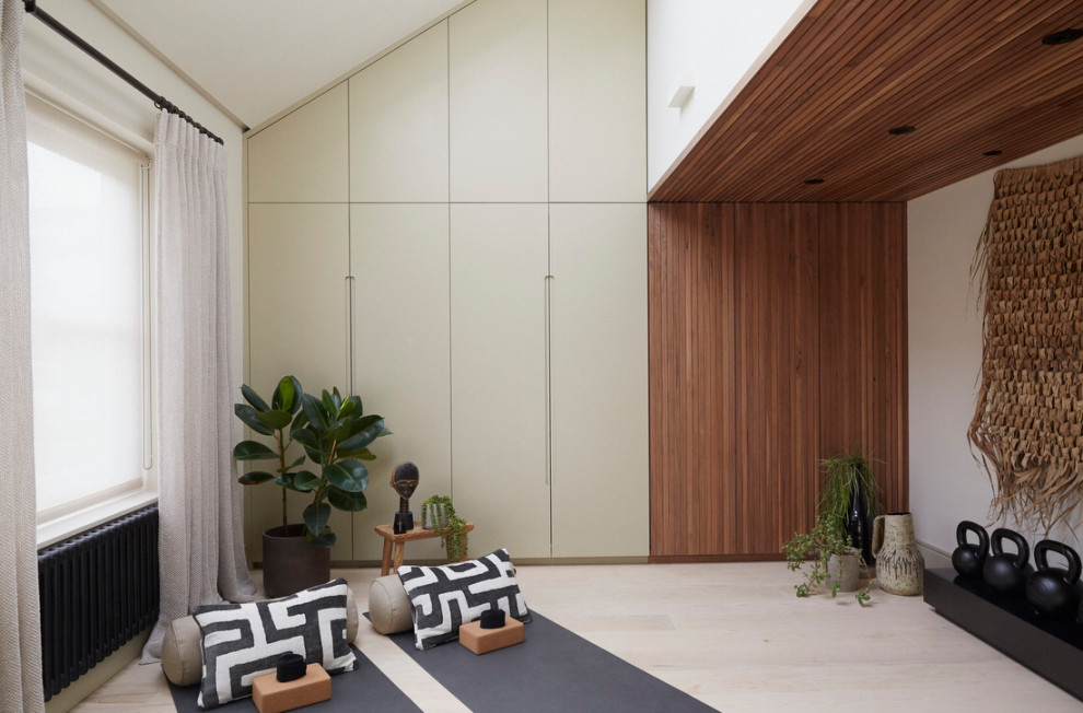 Cette image montre un grand studio de yoga design avec un mur beige, parquet clair, un sol beige et un plafond décaissé.