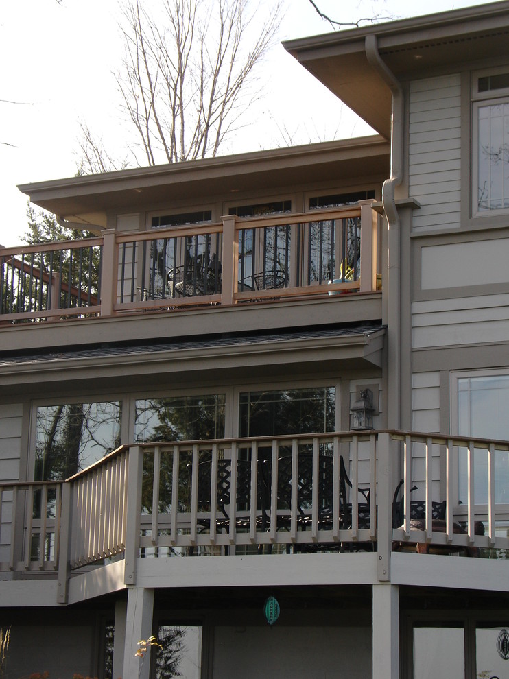 Photo of a large traditional three-storey beige house exterior in Milwaukee with concrete fiberboard siding.
