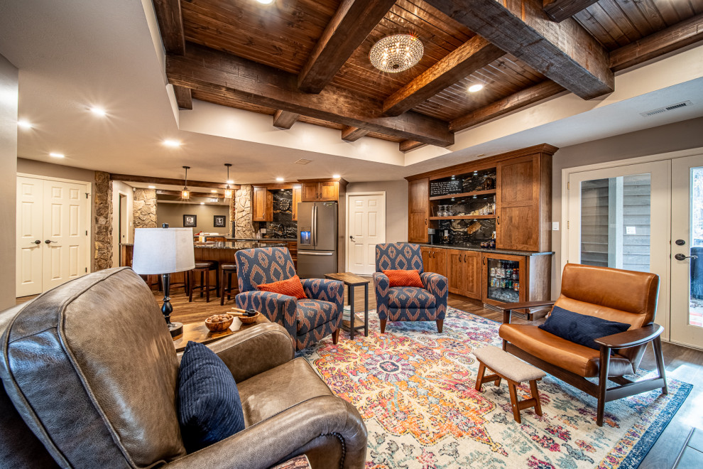 Large country walk-out basement in Other with brown walls, vinyl floors, a standard fireplace, a stone fireplace surround, brown floor and exposed beam.