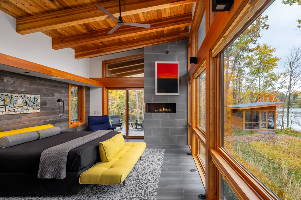 Bedroom - mid-sized rustic master porcelain tile, gray floor, exposed beam, vaulted ceiling, wood ceiling and wood wall bedroom idea in Minneapolis with a concrete fireplace, white walls and a corner fireplace