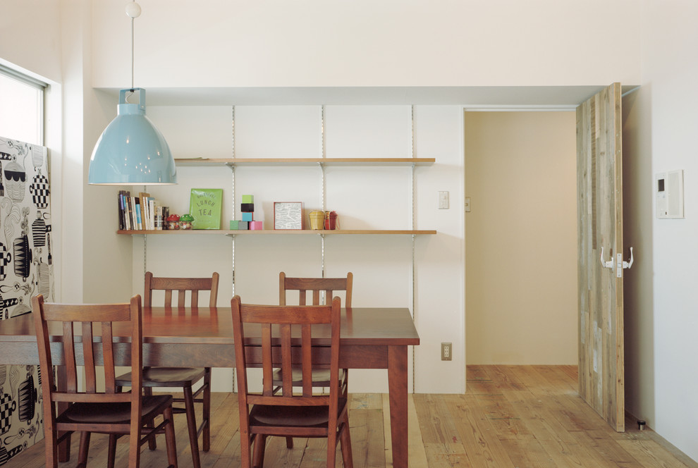 This is an example of a contemporary dining room in Nagoya with white walls, medium hardwood floors and brown floor.