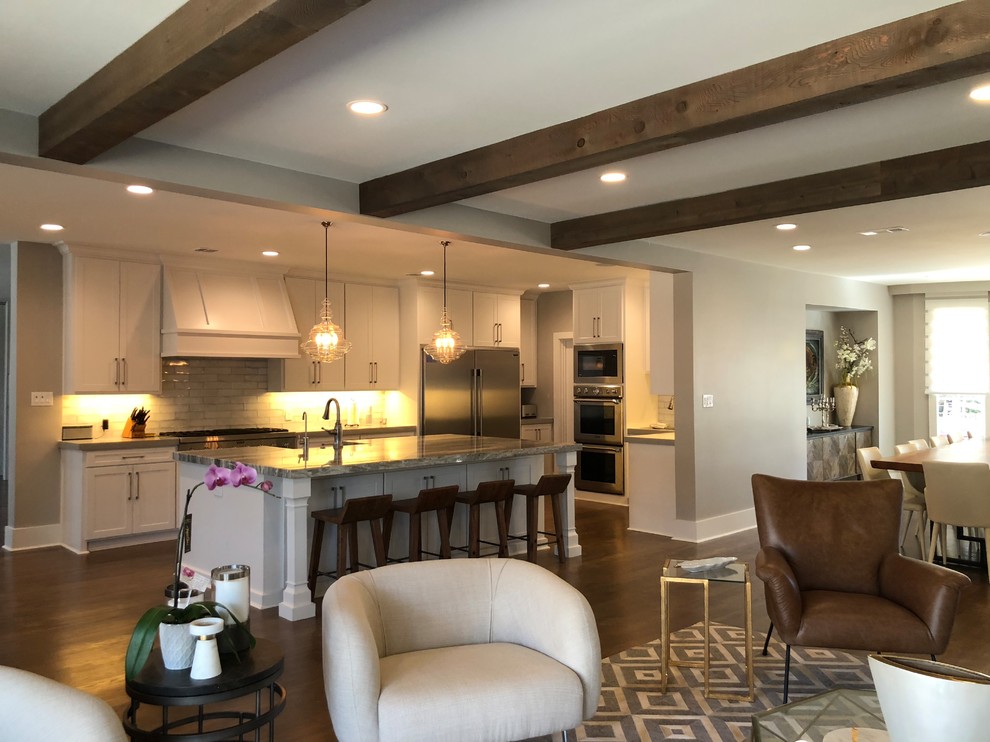 Inspiration for a large transitional l-shaped medium tone wood floor and brown floor open concept kitchen remodel in Dallas with an undermount sink, shaker cabinets, white cabinets, quartz countertops, gray backsplash, ceramic backsplash, stainless steel appliances and an island