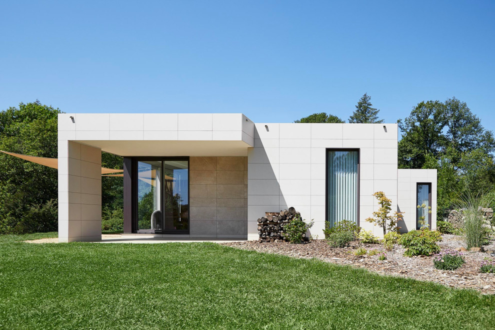 Стильный дизайн: одноэтажный, белый частный загородный дом среднего размера в стиле модернизм с плоской крышей - последний тренд