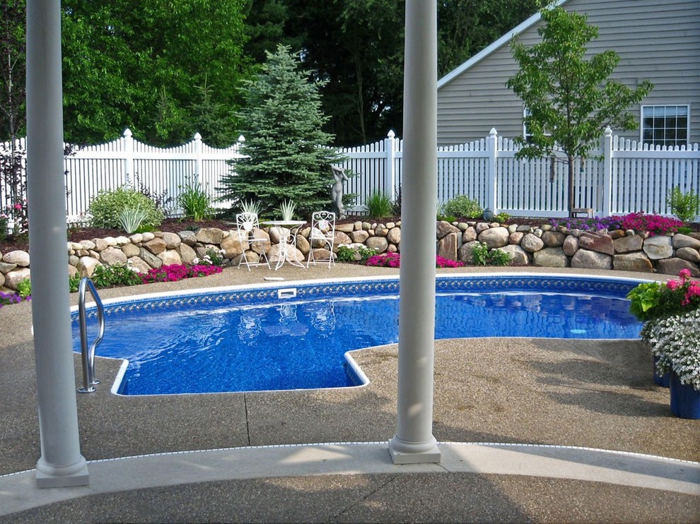 Example of a large backyard custom-shaped pool design in Grand Rapids
