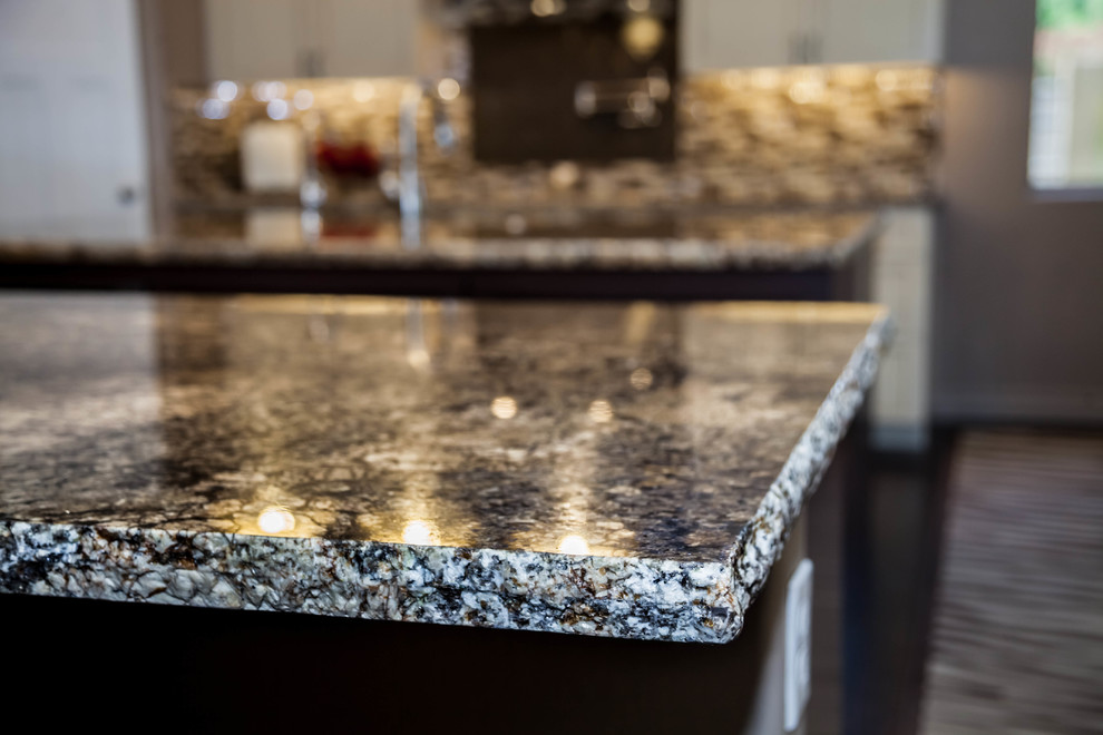 Large transitional l-shaped dark wood floor eat-in kitchen photo in Phoenix with an undermount sink, recessed-panel cabinets, white cabinets, granite countertops, multicolored backsplash, glass tile backsplash, stainless steel appliances and an island