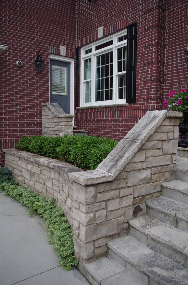 Photo of a mid-sized traditional front yard patio in Toronto with natural stone pavers.